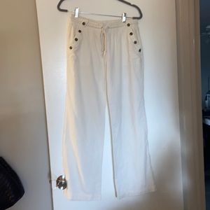 White linen pants with drawstring and accent buttons on pockets